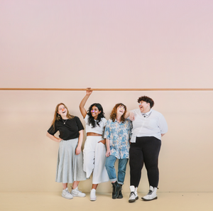 4 young friends standing in front of a wall wearing Nöz reef safe, vegan, and colorful SPF