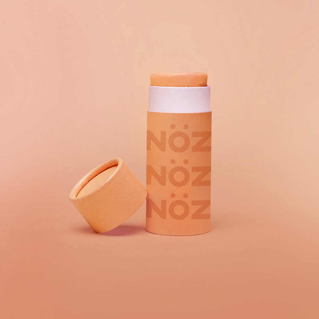 Colorful, reef safe, vegan Nöz sunscreen in a colorful orange hue