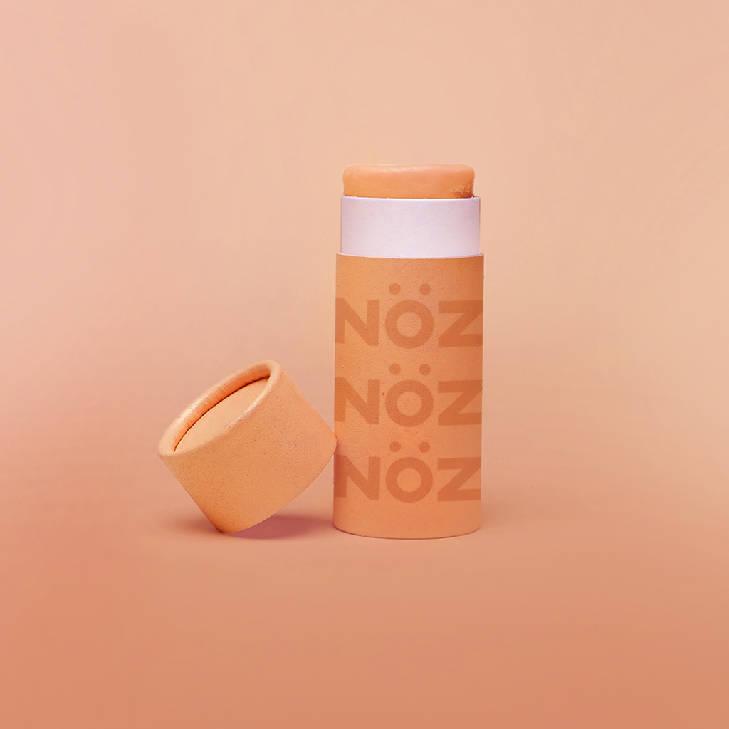 Colorful, reef safe, vegan Nöz sunscreen in a colorful orange hue